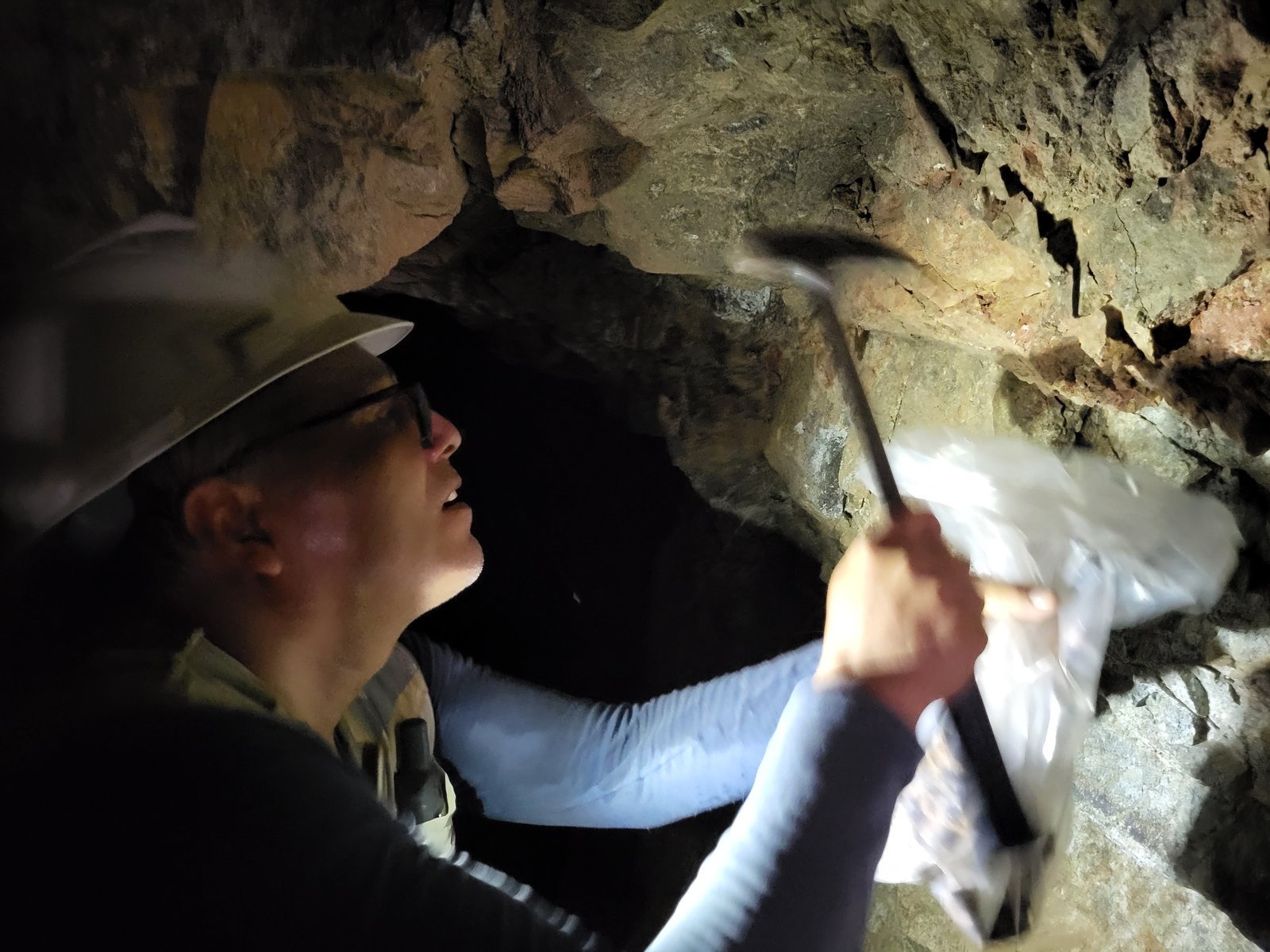 A Company geologist taking a sample from a vein underground